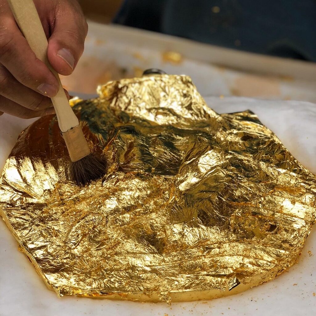 Working scene of gilding the on the bronze relief (23.4K gold leaf on the bronze) ブロンズレリーフへの箔押し作業風景(一号色金箔、ブロンズ)